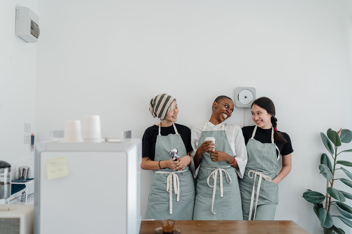 3 baristas standing behind bar